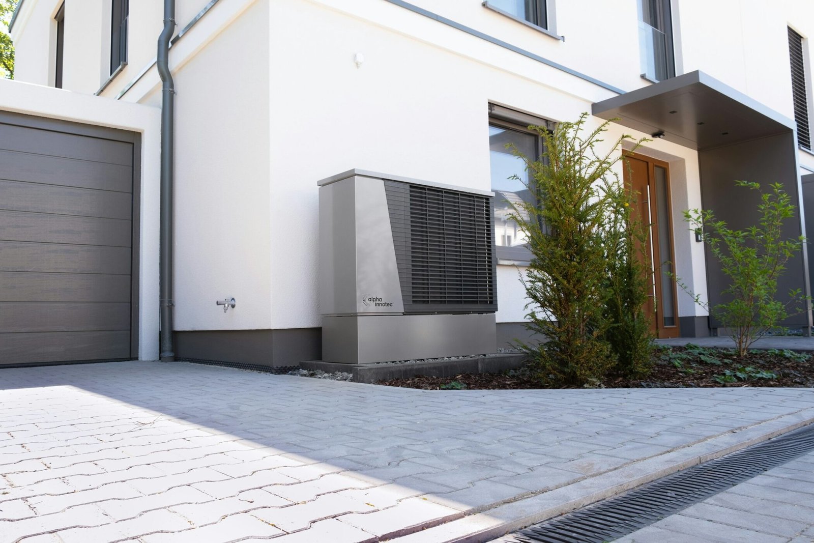 Maison contemporaine avec une pompe à chaleur air/eau posée au pied de la façade