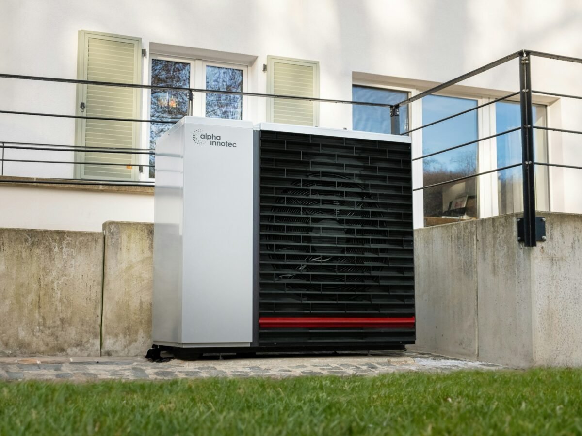 Unité extérieure d’une pompe à chaleur air/eau installée devant une maison