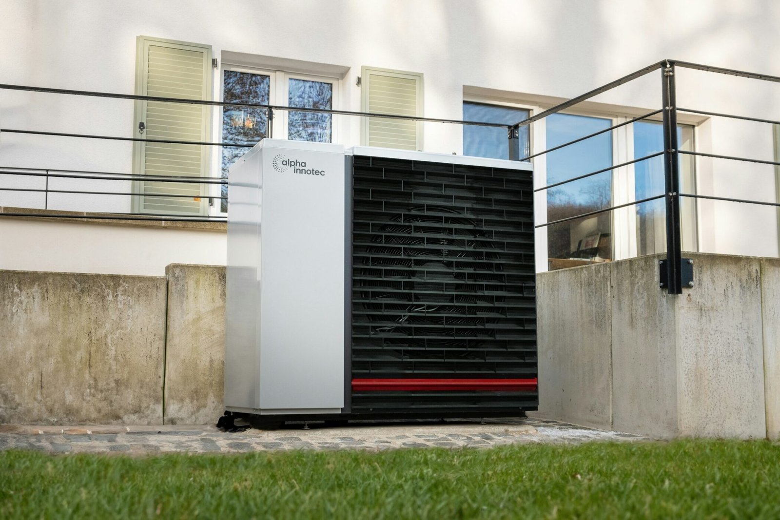 Unité extérieure d’une pompe à chaleur air/eau installée devant une maison