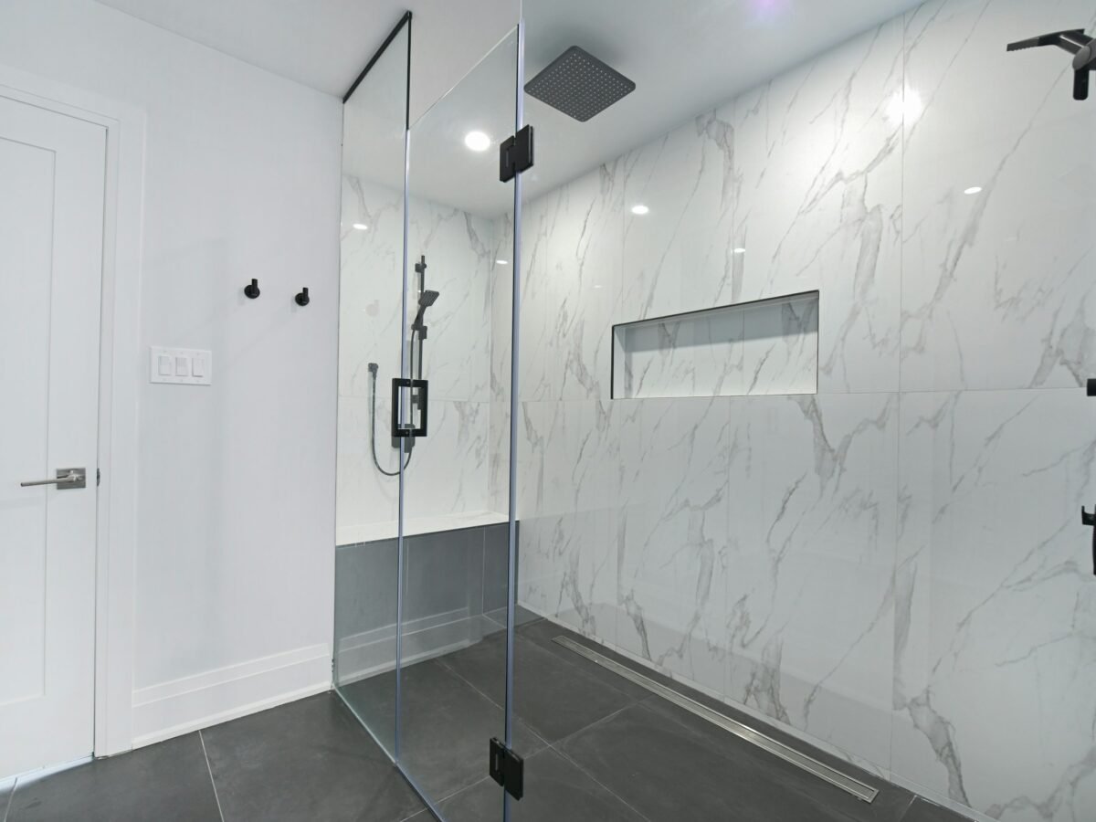 Douche à l’italienne avec paroi vitrée et revêtement mural façon marbre