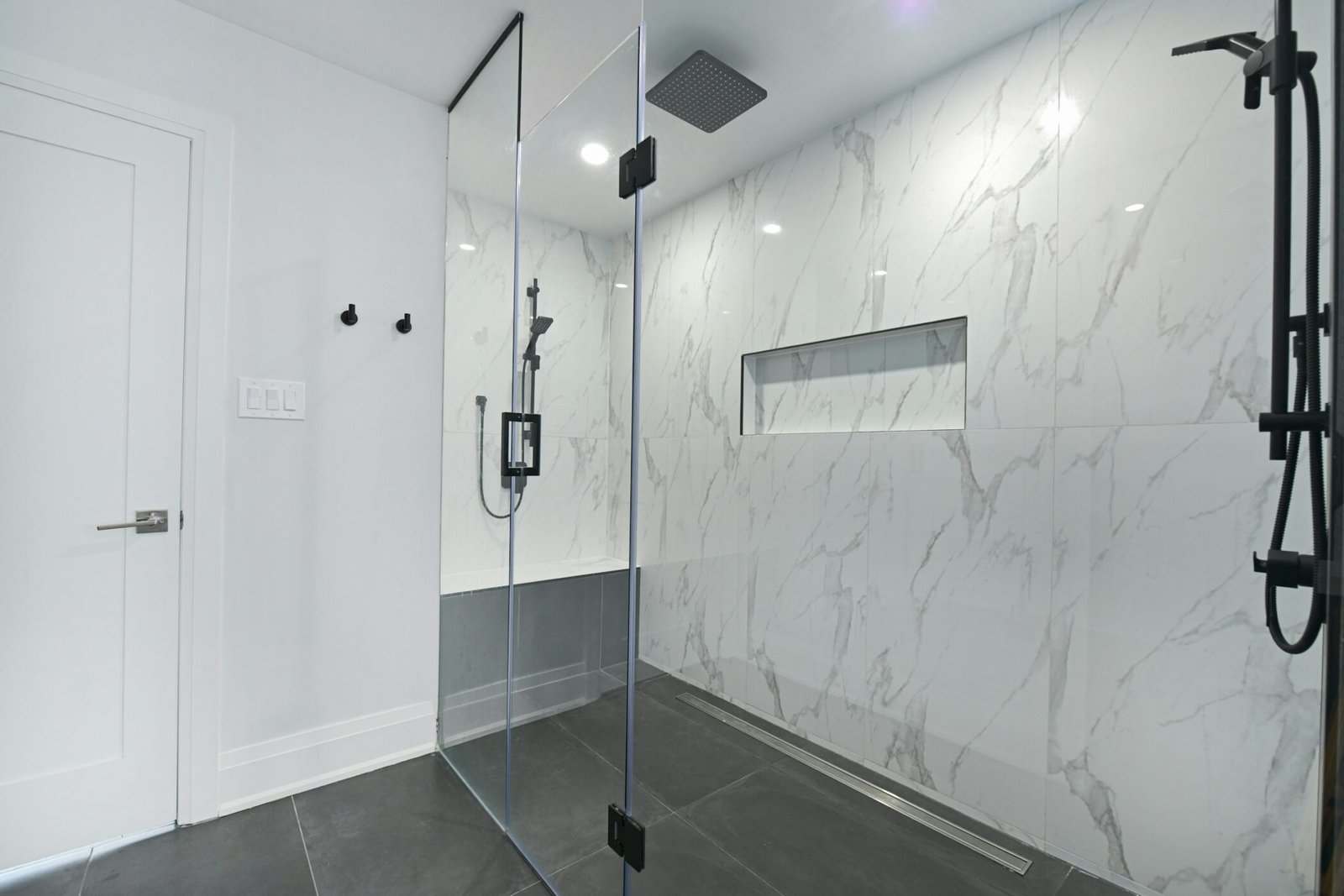 Douche à l’italienne avec paroi vitrée et revêtement mural façon marbre